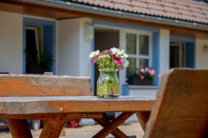 Holzbank mit Tisch und Blumen auf der Terrasse_Josenmuehle