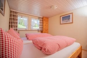 Ausblick vom Bett mit rot karierter Bettwäsche Ferienwohnung Kamille